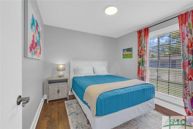 bedroom featuring wood finished floors and baseboards
