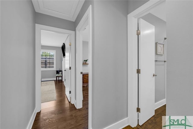 corridor featuring baseboards and dark wood-style flooring
