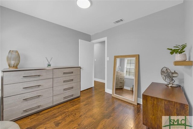 interior space featuring baseboards, visible vents, and dark wood-style floors