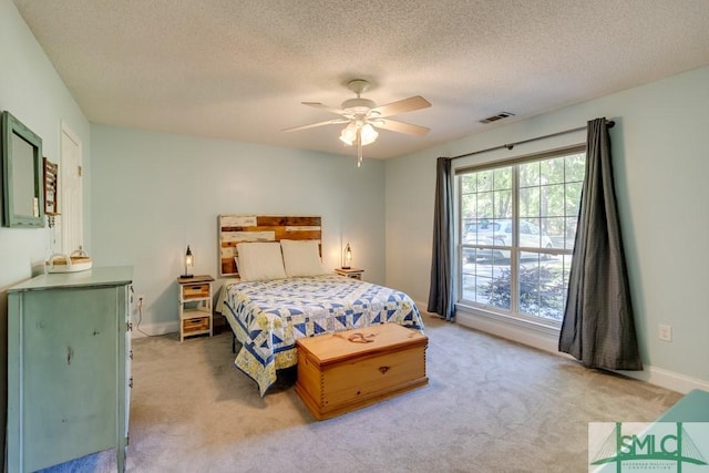 bedroom featuring baseboards, visible vents, a textured ceiling, and light colored carpet