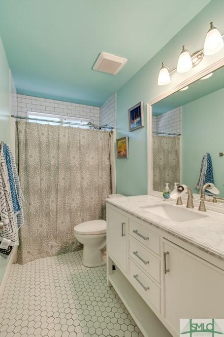 full bathroom with vanity, a shower with shower curtain, and toilet
