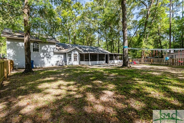 back of house with a sunroom, a fenced backyard, and a lawn