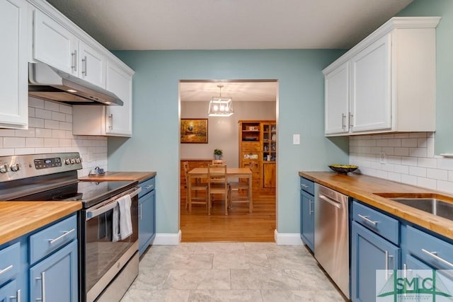 kitchen with butcher block counters, blue cabinets, stainless steel appliances, and under cabinet range hood