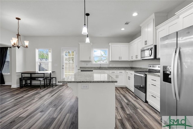 kitchen with stainless steel appliances, recessed lighting, white cabinetry, a kitchen island, and dark wood-type flooring