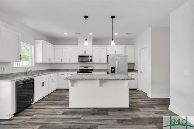 kitchen with recessed lighting, a center island, stainless steel appliances, and a sink