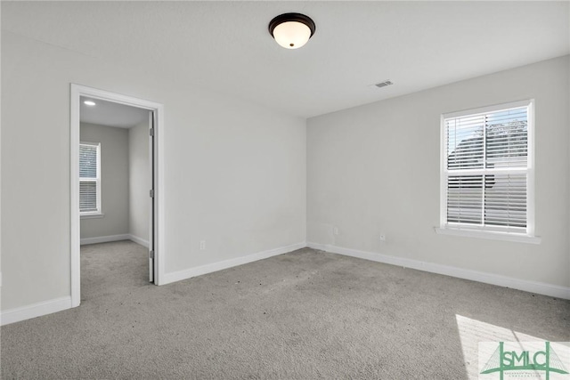 unfurnished room with baseboards, visible vents, and carpet