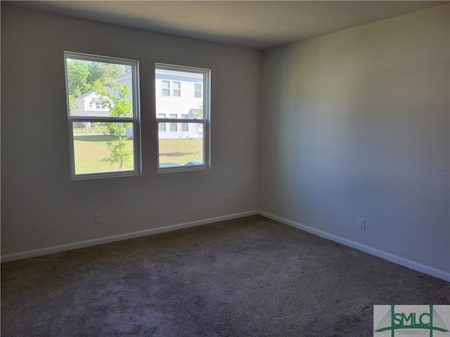 carpeted empty room featuring baseboards