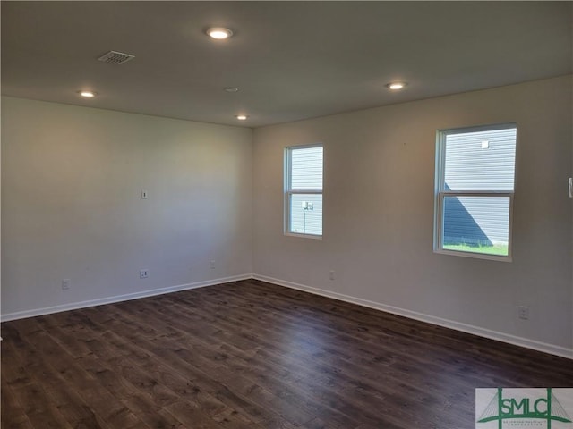 spare room featuring baseboards, dark wood-style flooring, visible vents, and recessed lighting