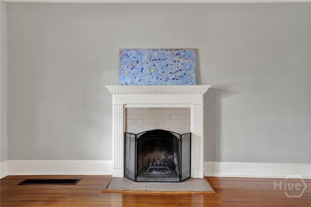128 E 48th St, Savannah, GA 31405 - detailed view of wood finished floors and a brick fireplace