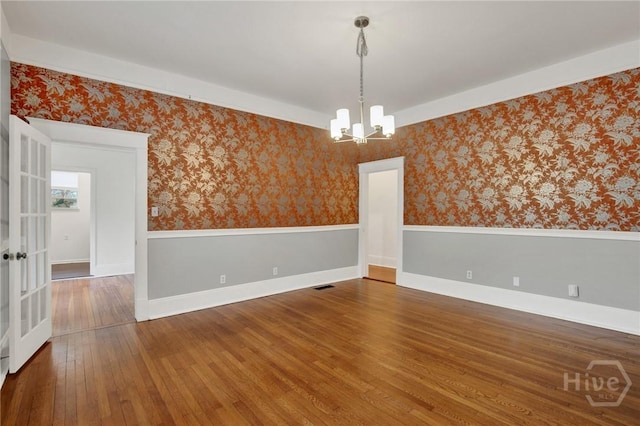 128 E 48th St, Savannah, GA 31405 - empty room featuring a chandelier, hardwood / wood-style floors, and wallpapered walls