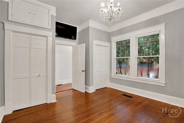 128 E 48th St, Savannah, GA 31405 - unfurnished bedroom featuring hardwood / wood-style floors and a chandelier