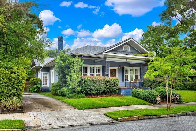 128 E 48th St, Savannah, GA 31405 - view of front of property featuring covered porch, a chimney, a front yard, and driveway