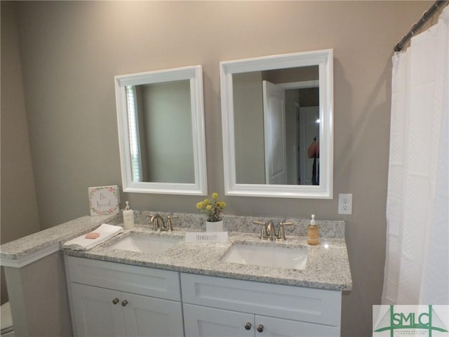 bathroom with a sink and double vanity