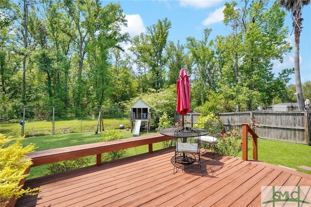 wooden deck with a lawn, outdoor dining area, and a fenced backyard