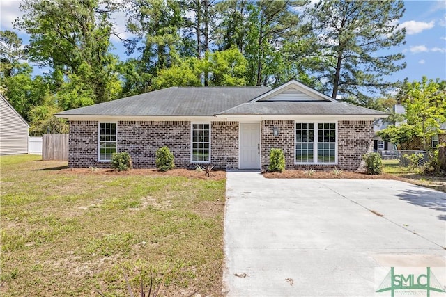 ranch-style home with brick siding, fence, and a front yard