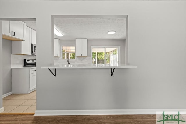 kitchen featuring a breakfast bar, tasteful backsplash, and white cabinetry