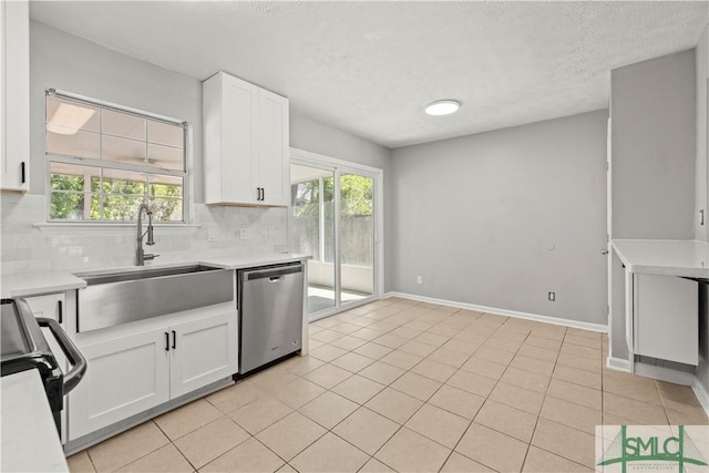 kitchen featuring stainless steel dishwasher, a sink, tasteful backsplash, white cabinetry, and light countertops