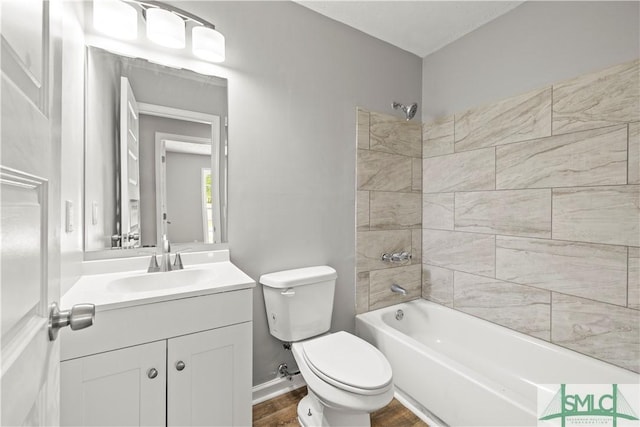 bathroom with toilet, vanity, wood finished floors, and shower / bath combination
