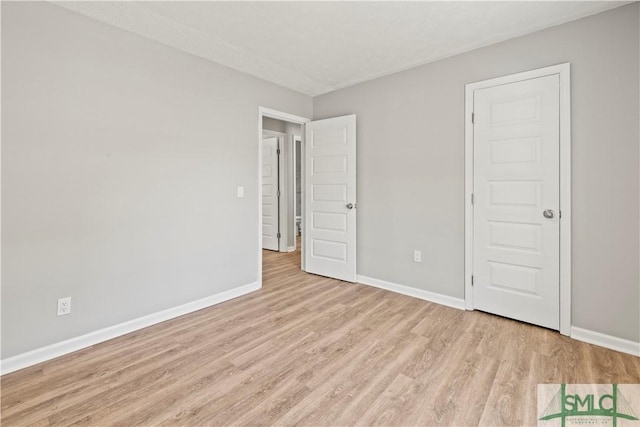 unfurnished bedroom featuring wood finished floors and baseboards