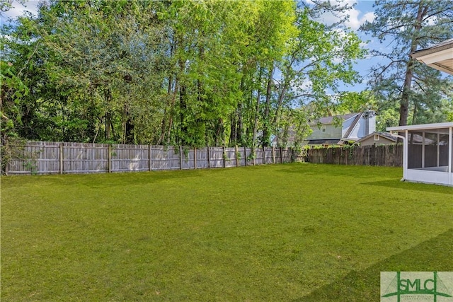 view of yard with a sunroom and a fenced backyard