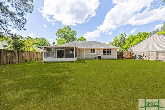 rear view of house featuring a yard, a sunroom, central AC, and a fenced backyard