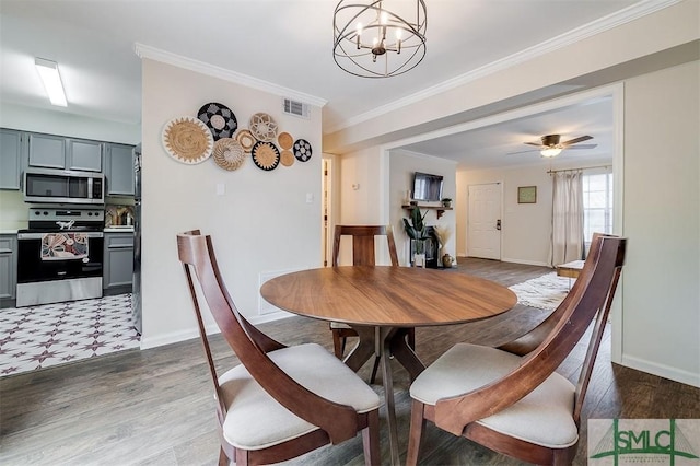 dining room featuring a chandelier, baseboards, wood finished floors, ornamental molding, and a ceiling fan