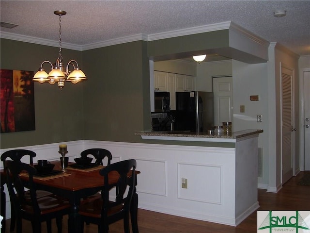 dining area with a notable chandelier, crown molding, dark wood-style flooring, and a textured ceiling