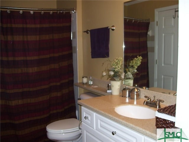 bathroom with vanity, a shower with shower curtain, and toilet