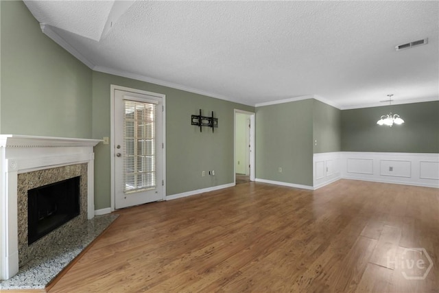 12300 Apache Ave Unit 1212, Savannah, GA 31419 - unfurnished living room with a textured ceiling, wood finished floors, a high end fireplace, ornamental molding, and a chandelier