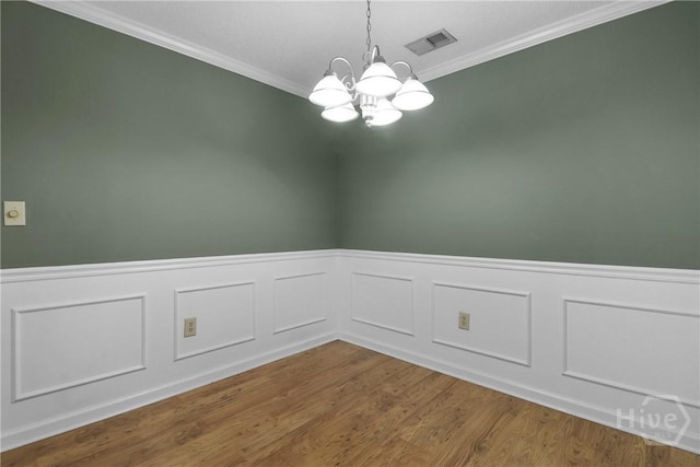 12300 Apache Ave Unit 1212, Savannah, GA 31419 - empty room with a chandelier, ornamental molding, a wainscoted wall, and wood finished floors