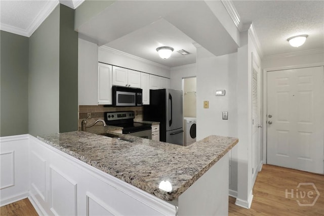 12300 Apache Ave Unit 1212, Savannah, GA 31419 - kitchen featuring appliances with stainless steel finishes, a sink, a peninsula, light stone countertops, and light wood-type flooring