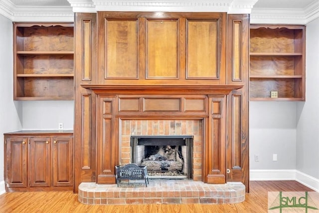room details with wood finished floors, a brick fireplace, baseboards, and ornamental molding