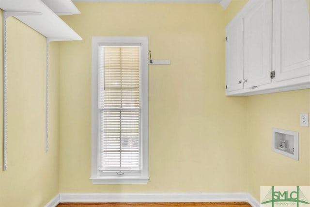 laundry area featuring baseboards, hookup for a washing machine, and cabinet space