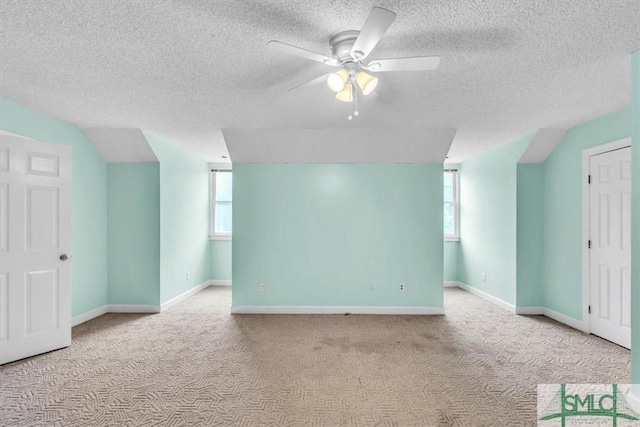 interior space with carpet floors, a textured ceiling, and a ceiling fan