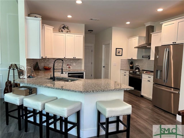 kitchen featuring appliances with stainless steel finishes, a sink, a peninsula, backsplash, and visible vents