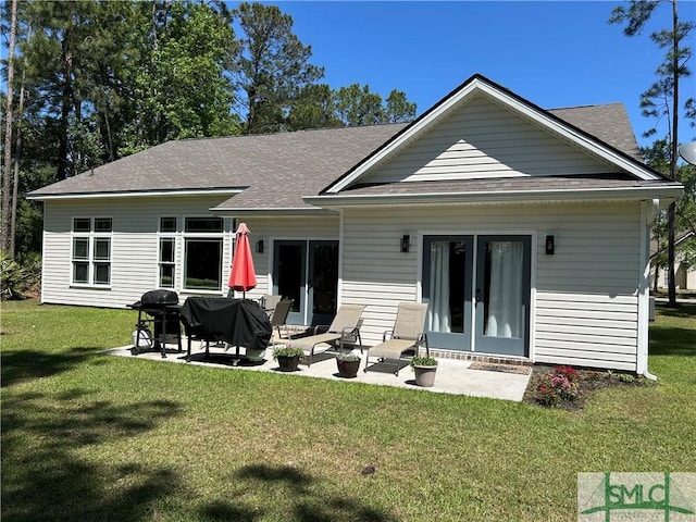back of house featuring a patio, a shingled roof, a lawn, and french doors