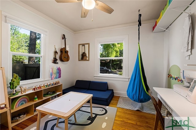 game room featuring wood finished floors, ceiling fan, and crown molding