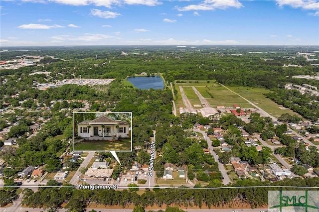 bird's eye view featuring a wooded view and a water view