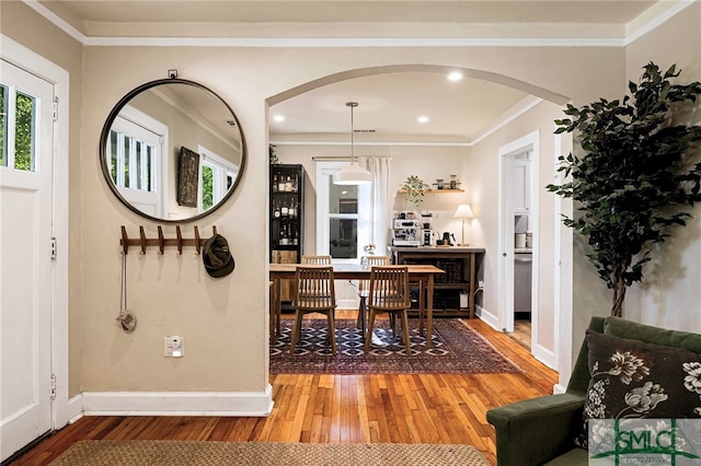 interior space with recessed lighting, hardwood / wood-style floors, arched walkways, crown molding, and baseboards