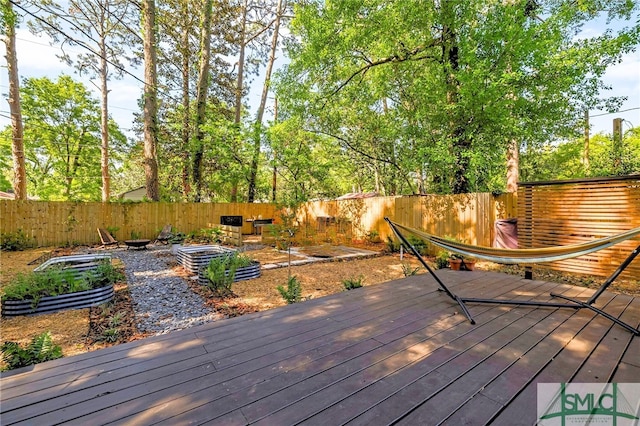 deck featuring a vegetable garden and a fenced backyard