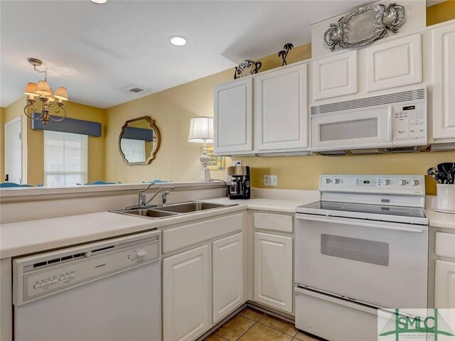 2 17th St Unit H 8, Tybee Island, GA 31328 - kitchen with white appliances, a sink, white cabinetry, a chandelier, and light tile patterned flooring