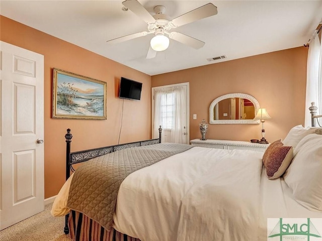 carpeted bedroom featuring a ceiling fan and visible vents