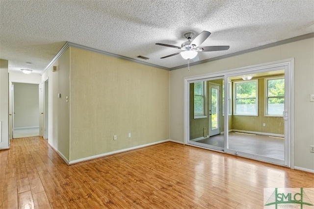 unfurnished room with wood finished floors, visible vents, crown molding, and a ceiling fan