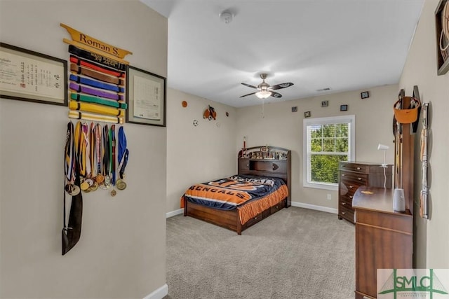 carpeted bedroom with visible vents, a ceiling fan, and baseboards