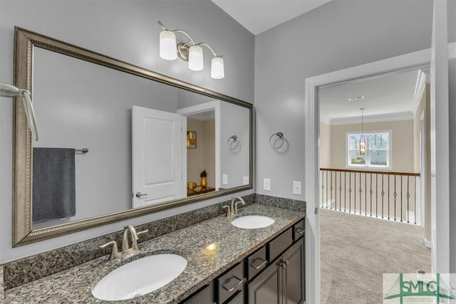 bathroom featuring double vanity, an inviting chandelier, and a sink