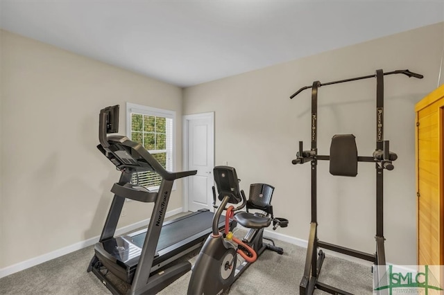 exercise room with baseboards and carpet floors