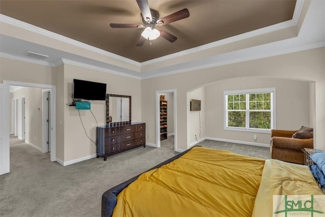 bedroom with a raised ceiling, visible vents, carpet floors, crown molding, and baseboards