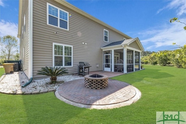 back of property featuring central AC, a lawn, an outdoor fire pit, a patio, and a sunroom
