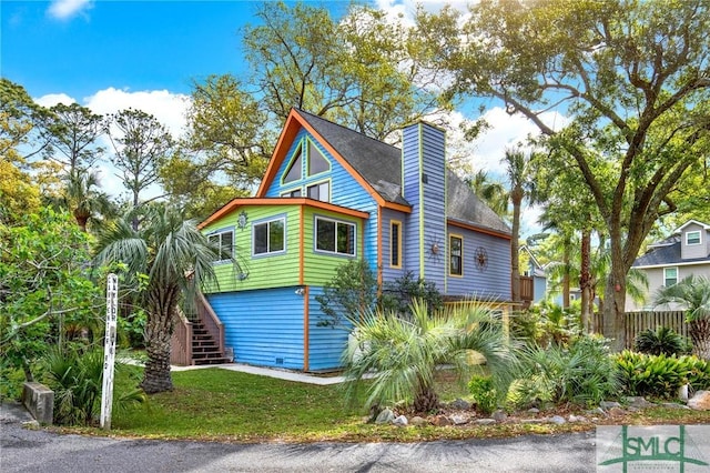12 Carpenter Rd, Tybee Island, GA 31328 - view of property exterior with stairway and a chimney