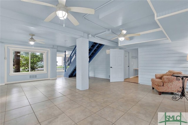 12 Carpenter Rd, Tybee Island, GA 31328 - living area with light tile patterned floors, stairs, ceiling fan, and wood walls